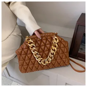 Detailaufnahme der braunen gesteppten PU-Ledertasche mit einer dicken Goldkette.