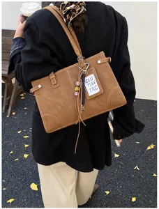 Vintage brown large capacity commuter shoulder bag shown from a back-carried perspective