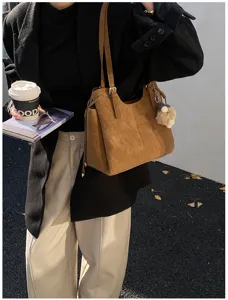 Large capacity brown faux suede commuter tote bag for women shown with lifestyle accessories