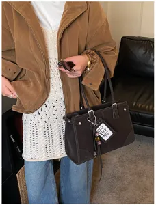 Detail view of a vintage dark brown tote bag styled with a casual chic autumn outfit.