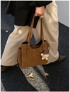 Detailed street style view of a large brown soft leather tote bag for commuting.