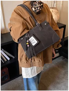 Detailed lifestyle view of a large brown vintage tote bag featuring decorative stitching