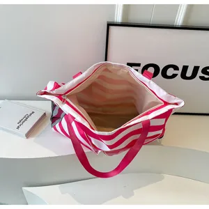 Detailansicht der Innenseite einer rosa-weiß gestreiften Tragetasche mit Stauraum