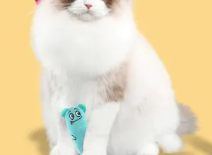 Primo piano del giocattolo blu per gatti con erba gatta e faccia buffa tenuto da un gatto.