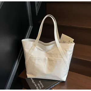 Nahaufnahme der weißen strukturierten Tragetasche mit TOTE BAG-Prägung