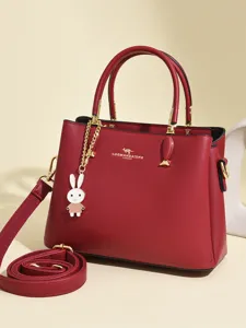 Elegant red wedding handbag for women with kangaroo logo and a cute decorative rabbit charm.