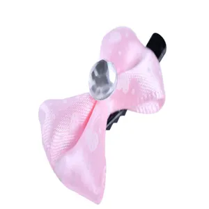 Gros plan sur une pince à nœud rose pour animaux avec motif cœur et strass