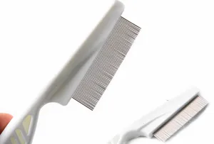 Vue détaillée des dents fines en acier inoxydable d'un peigne à puces blanc de 18 cm.