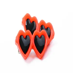 Vista de cerca de pinzas para el cabello con forma de corazón naranja para mascotas