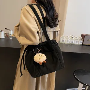 Vintage corduroy shoulder bag for women, large capacity commuter crossbody bag with plush charm.