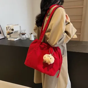 Red corduroy shoulder bag, vintage commuter crossbody bag with drawstring and cute plush pendant.