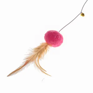 Detail of cat teaser toy featuring a pink plush ball, feathers, and a small gold bell