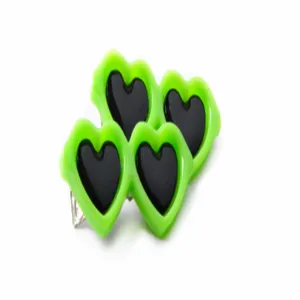 Primer plano de pinzas para el pelo de mascotas con forma de corazón verde y negro