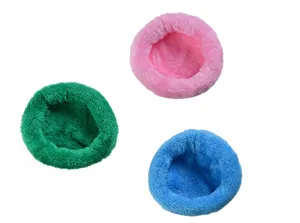 Close-up detail of three plush warm hamster nests in soft pink, green, and blue