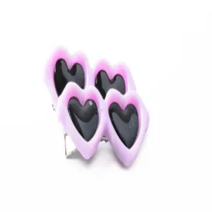 Primer plano de tres pinzas decorativas rosas en forma de corazón para mascotas