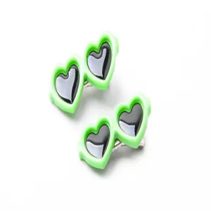 Primer plano de dos pinzas para el pelo de mascotas con forma de gafas de corazón verde neón