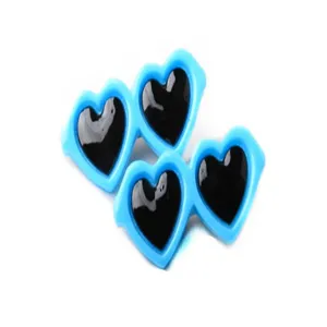 Primer plano de pinzas para el pelo de mascotas con forma de corazón azul y centro negro brillante