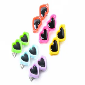 Primer plano de pinzas para el pelo con forma de gafas de sol de corazón para mascotas