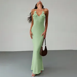 Detailed shot of a stylish green knit halter maxi dress with floral accents for beachwear.
