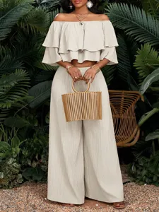 Nahaufnahme des beigen schulterfreien Rüschen-Crop-Tops und der High-Waist-Hose im Resort-Set.