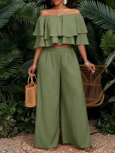 Detailansicht des tropischen schulterfreien Rüschen Crop Tops und der weiten Hose.