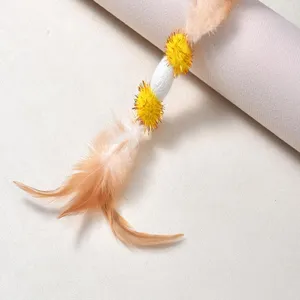 Detailed macro shot of the natural feather cat teaser toy with silk cocoons and pom-poms