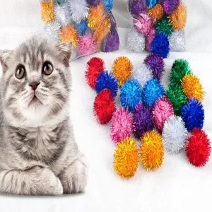 Dettaglio di palline pompon glitterate da 3cm per gatti su sfondo di pelliccia