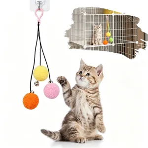 Detail showing hanging cat toy with colorful plush balls and bells for cage entertainment