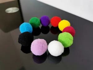 Macro-opname van kleurrijke 3cm polyester elastische pomponballen voor kattenspel.