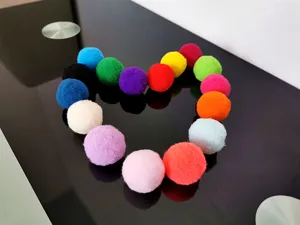 Gekleurde polyester pompon kattenspeeltjes gerangschikt in hartvorm