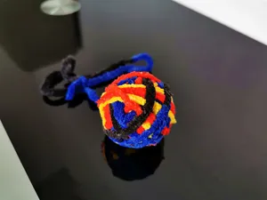 Primo piano di un colorato gioco per gatti a palla di lana con coda lunga