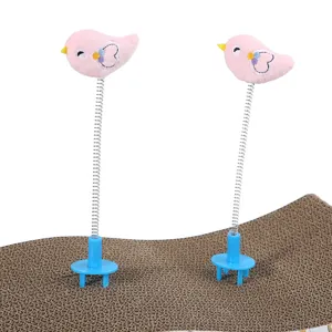 Dettaglio di due giocattoli a molla per gatti a forma di uccellino rosa su cartone