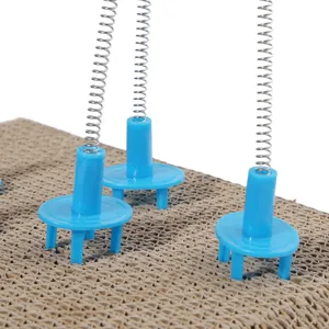 Dettaglio di un tiragraffi in cartone per gatti con attacchi blu per giocattoli a molla.