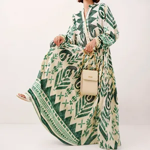 Detailed view of the elegant green patterned long dress, featuring a chic V-neck and sleeves.