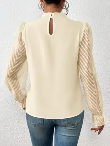 Detail van de achteraanzicht van beige chiffon top met lange mouwen en hoge kraag en patroon.