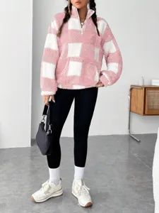 Pink and white checkerboard fleece half-zip sweatshirt detail showing cozy plush texture.