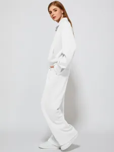 Detail view of womens half zip sweatshirt and wide leg sweatpants tracksuit in solid white.