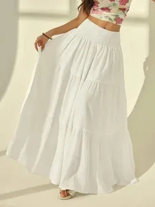 Detailed shot of the elegant white tiered maxi skirt showcasing its flowy texture and waist.