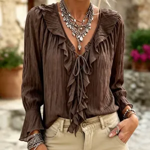 Close-up detail of the brown ruffled V-neck long sleeve blouse with elegant tie and pleats.