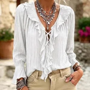 Detailed view of white ruffle lace-up flare sleeve V-neck top in outdoor scene.