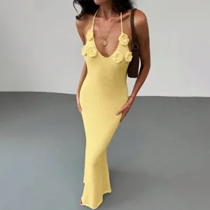 Detail view of a stunning yellow knit halter maxi dress featuring chic 3D floral accents.