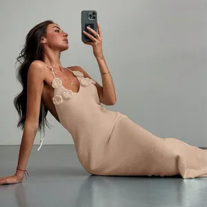 Elegant beige knit halter maxi dress featuring 3D floral details for chic beach style.
