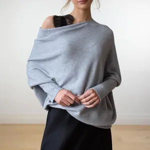 Vue détaillée du élégant pull en tricot gris à épaules dénudées et manches longues.