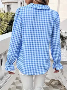 Nahaufnahme der blauen und weißen karierten Bluse mit schickem Rüschenkragen und Ärmeln.