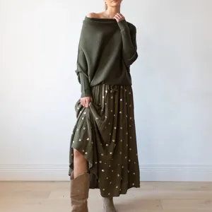 Vue détaillée du pull tricoté à manches longues élégant et de la jupe plissée en vert.