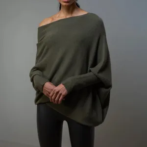 Gros plan détaillé du pull en tricot vert foncé avec un design élégant à manches chauve-souris.