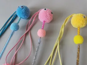 Colorful plush cat teaser wand details showing fluffy pom-poms and long ropes for pets play.