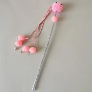 Detailed view of pink cat teaser wand with fluffy pom-poms and bells, interactive pet toy.