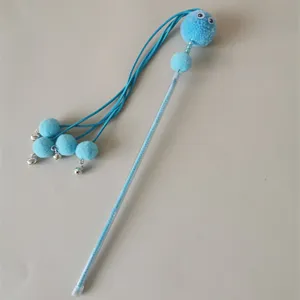 Close-up of interactive cat teasing wand featuring blue plush balls, bells, and clear stick.