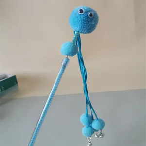 Cat teaser wand detail showing the fluffy blue pom-pom head and small bells for pet play.